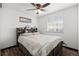 Bright bedroom with wood-look floors, a ceiling fan, and built-in shelves above the bed at 8571 S Estes St, Littleton, CO 80128