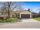 Charming ranch style home features a two-car garage, manicured lawn, and mature trees at 8571 S Estes St, Littleton, CO 80128