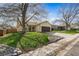Charming home with a well-maintained lawn, a tree-lined yard, and a two-car garage at 8571 S Estes St, Littleton, CO 80128