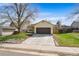 Ranch style home with a two-car garage, well-kept lawn, mature landscaping, and a peaceful neighborhood setting at 8571 S Estes St, Littleton, CO 80128