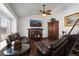 Cozy living room with a brick fireplace, ceiling fan, and hardwood floors, creating a warm and inviting space at 8571 S Estes St, Littleton, CO 80128