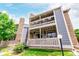Charming condo building featuring stone accents, a covered porch, and well-maintained landscaping at 8335 Fairmount Dr # 10-208, Denver, CO 80247