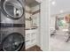 Stackable laundry units in the laundry room provide easy access to the bedroom at 8335 Fairmount Dr # 10-208, Denver, CO 80247