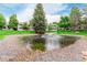 Scenic community pond with a fountain and lush landscaping near condominium buildings at 8335 Fairmount Dr # 10-208, Denver, CO 80247