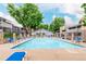 Community pool surrounded by lounge chairs and well-maintained landscaping at 8335 Fairmount Dr # 10-208, Denver, CO 80247