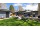 A beautiful backyard features a patio, detached garage, seating, and mature landscaping at 1321 S Edison Way, Denver, CO 80222