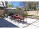 A backyard with a dining table, grill, seating, stone retaining wall, grassy area and string lights at 1321 S Edison Way, Denver, CO 80222