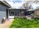 A large backyard featuring a patio, detached garage, outdoor dining, seating, and mature trees at 1321 S Edison Way, Denver, CO 80222