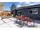 A modern backyard patio with a dining table, chairs, and thoughtful landscaping makes this home great for entertaining at 1321 S Edison Way, Denver, CO 80222
