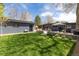 An expansive backyard with a detached garage, patio, outdoor dining, and lush lawn at 1321 S Edison Way, Denver, CO 80222