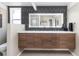 Modern bathroom featuring double sinks, a large backlit mirror, and geometric wallpaper at 1321 S Edison Way, Denver, CO 80222