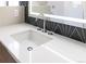 Bright bathroom sink with white countertop, modern faucet, and geometric backsplash at 1321 S Edison Way, Denver, CO 80222