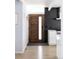 Bright entryway with wood flooring, modern door, black tile backsplash, and a glimpse of the kitchen at 1321 S Edison Way, Denver, CO 80222