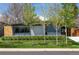 Modern home featuring a gray exterior, well-maintained lawn, and young trees in a serene suburban setting at 1321 S Edison Way, Denver, CO 80222