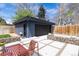 The exterior of the garage shows the concrete tile patio, stylish landscaping, and a bonus door for backyard access at 1321 S Edison Way, Denver, CO 80222