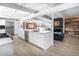 Open-concept kitchen with white cabinetry, stainless steel appliances, island sink, and an adjacent living area at 1321 S Edison Way, Denver, CO 80222