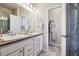 Well-lit Primary bathroom with double sinks, tile flooring, and a walk-in shower at 6834 Clay N St, Denver, CO 80221