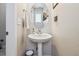Clean half bath with pedestal sink, oval mirror, and modern fixtures at 6834 Clay N St, Denver, CO 80221