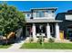 Charming two-story home with a covered porch, a green lawn, and manicured landscaping at 6834 Clay N St, Denver, CO 80221