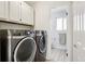 The laundry room boasts modern washer and dryer, plus storage cabinets at 4759 S Xenophon St, Morrison, CO 80465
