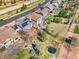 An aerial view shows a fenced backyard with a trampoline, patio and mature trees with a neighborhood road at 2208 Bellavista St, Castle Rock, CO 80109