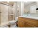 Cozy bathroom featuring a shower with glass doors, light wood vanity, and modern glass bowl sink at 2208 Bellavista St, Castle Rock, CO 80109