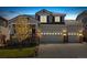 A warm and inviting two-story home at dusk, featuring a three-car garage and a well-manicured lawn at 2208 Bellavista St, Castle Rock, CO 80109