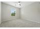 Empty bedroom with a large window, ceiling fan, and soft carpet at 2648 Florence St, Denver, CO 80238