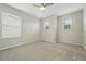 Bright bedroom with plush carpeting, ceiling fan, and windows providing natural light at 2648 Florence St, Denver, CO 80238