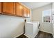 Laundry room with upper cabinets and modern washer and dryer at 2648 Florence St, Denver, CO 80238