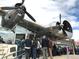 People lined up to enter a building with a crashed airplane coming out of it; tourist attraction at 2648 Florence St, Denver, CO 80238