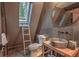 Modern bathroom features a unique sink and mirror, a skylight, and dark tiled walls at 563 Cr 672, Breckenridge, CO 80424
