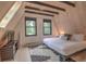 Cozy bedroom featuring light wood walls and floors, a comfortable bed, and windows providing views of the surrounding trees at 563 Cr 672, Breckenridge, CO 80424