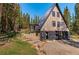 A-frame house exterior showcasing the entrance, landscaping, and wooded setting at 563 Cr 672, Breckenridge, CO 80424