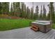 Hot tub on a deck with a picturesque view of tall pine trees and lush green grass at 563 Cr 672, Breckenridge, CO 80424