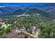 Aerial view of an estate surrounded by lush greenery and rolling hills at 9310 S Watson Gulch Rd, Littleton, CO 80127