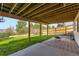 Covered back patio featuring a concrete and brick patio with a grassy area, perfect for outdoor living at 11715 Crow Hill Dr, Parker, CO 80134