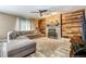 Cozy living room with a stone fireplace, wood accent wall, and comfortable seating at 22160 Wintergreen Way, Parker, CO 80138