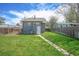 Back exterior featuring a well-manicured lawn, pathway, and privacy fence at 833 Osceola St, Denver, CO 80204