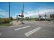 Wide shot of a neighborhood crossing with railroad, crosswalk and street lights on a sunny day at 833 Osceola St, Denver, CO 80204