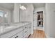 Bathroom with a double vanity and mirror as well as closet and wood floors at 10912 Memphis Ct, Commerce City, CO 80022