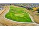 Green grass, sand traps, winding paths, and colorful trees dot a scenic golf course at 10912 Memphis Ct, Commerce City, CO 80022