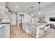 Bright kitchen with a large island, stainless steel appliances, and modern pendant lighting at 10912 Memphis Ct, Commerce City, CO 80022