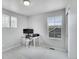 Office area includes a computer desk with chair, grey walls, and two windows for natural light at 10912 Memphis Ct, Commerce City, CO 80022