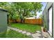 Inviting backyard featuring a large tree, green grass, stepping stones and wood fence at 1331 Osceola St, Denver, CO 80204