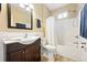 Cozy bathroom with a classic vanity, a bathtub and shower combination, and neutral tiling at 1331 Osceola St, Denver, CO 80204