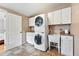 Functional laundry room with stacked washer and dryer, built-in cabinets, and utility sink at 1331 Osceola St, Denver, CO 80204