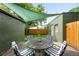 Cozy outdoor patio under green shade cover, complete with a dining table and striped chairs at 1331 Osceola St, Denver, CO 80204