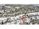 Aerial view of a neighborhood with snow-covered homes and a red arrow pointing to a property at 6366 Nassau Ct, Highlands Ranch, CO 80130