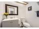 Clean, well-lit half bathroom with a modern vanity, mirror, and toilet at 6366 Nassau Ct, Highlands Ranch, CO 80130